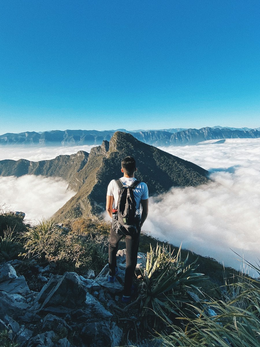 Traveler standing on a mountain summit above the clouds in Mexico